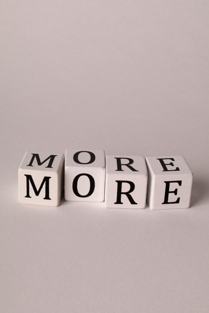 Black and white dice spelling 'MORE' on a white background, perfect for text concepts.